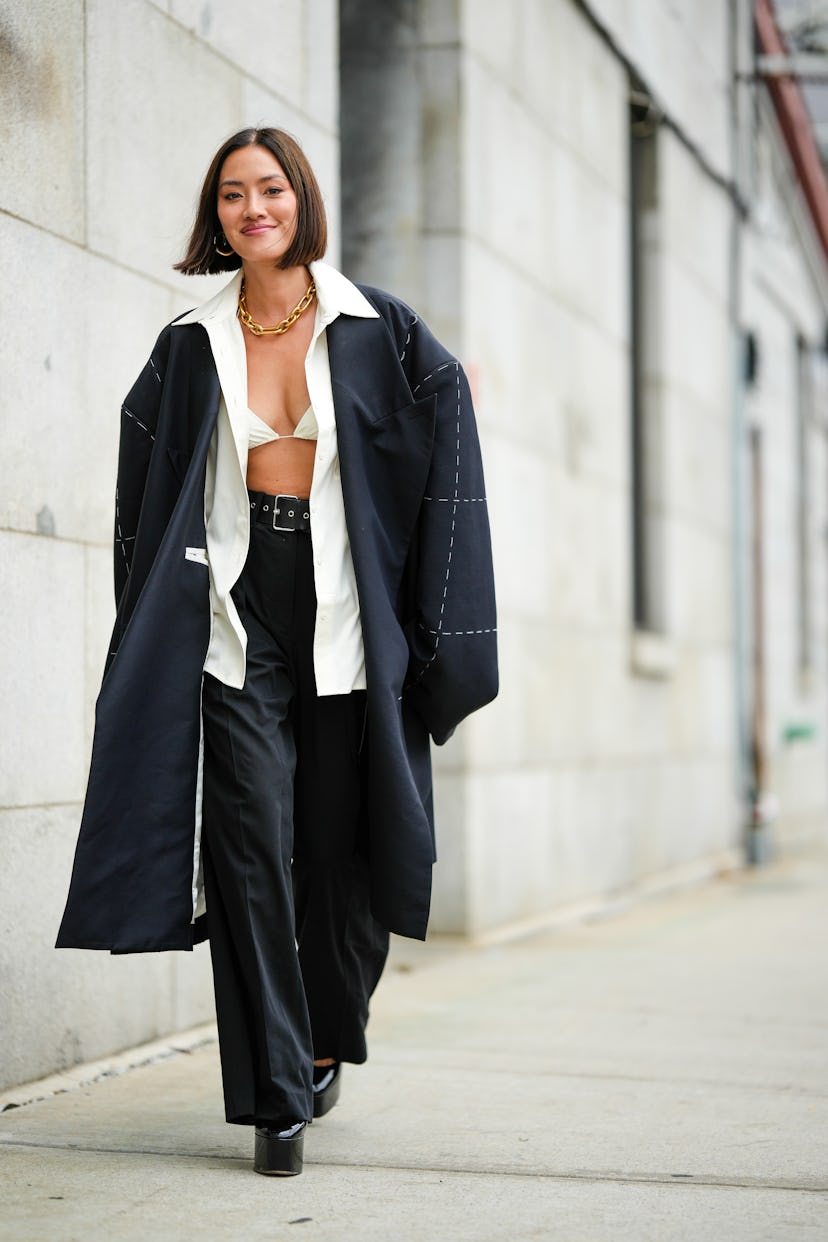 Tiffany Hsu wears a gold chain necklace, a white shirt and a black oversized coat at the New York Fa...