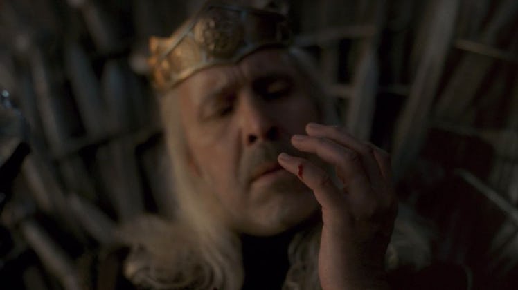 Paddy Considine as King Viserys I Targaryen cutting his finger on the iron throne.