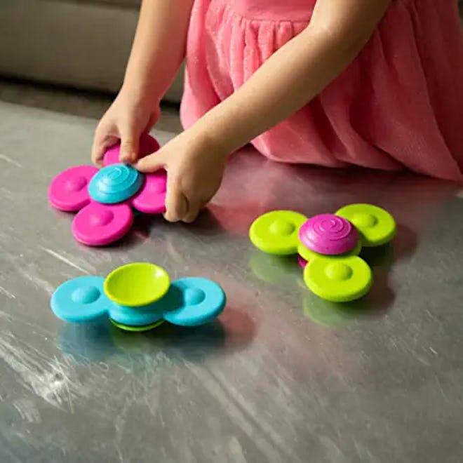 Spinning toys that stick to hard surfaces can go anywhere to keep little ones entertained.