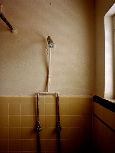 A shower with yellow tiles