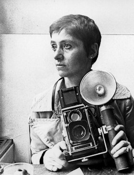 A young Diane Arbus holding up a camera in 1968