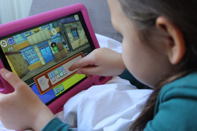 A young child using the CodeSpark Academy app on their iPad
