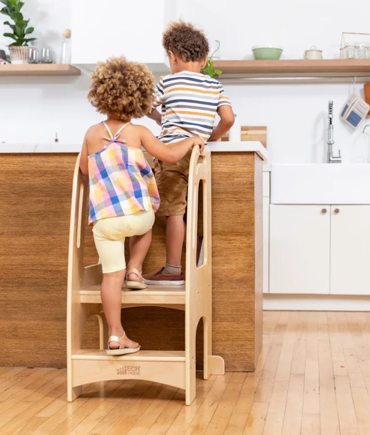 Two toddlers on blond wood learning tower