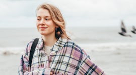 Young woman wearing an autumn shacket during the 2022 fall equinox, which will affect every zodiac s...