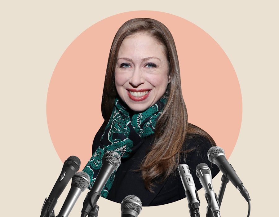 Chelsea Clinton on an orange background with microphones in front of her 