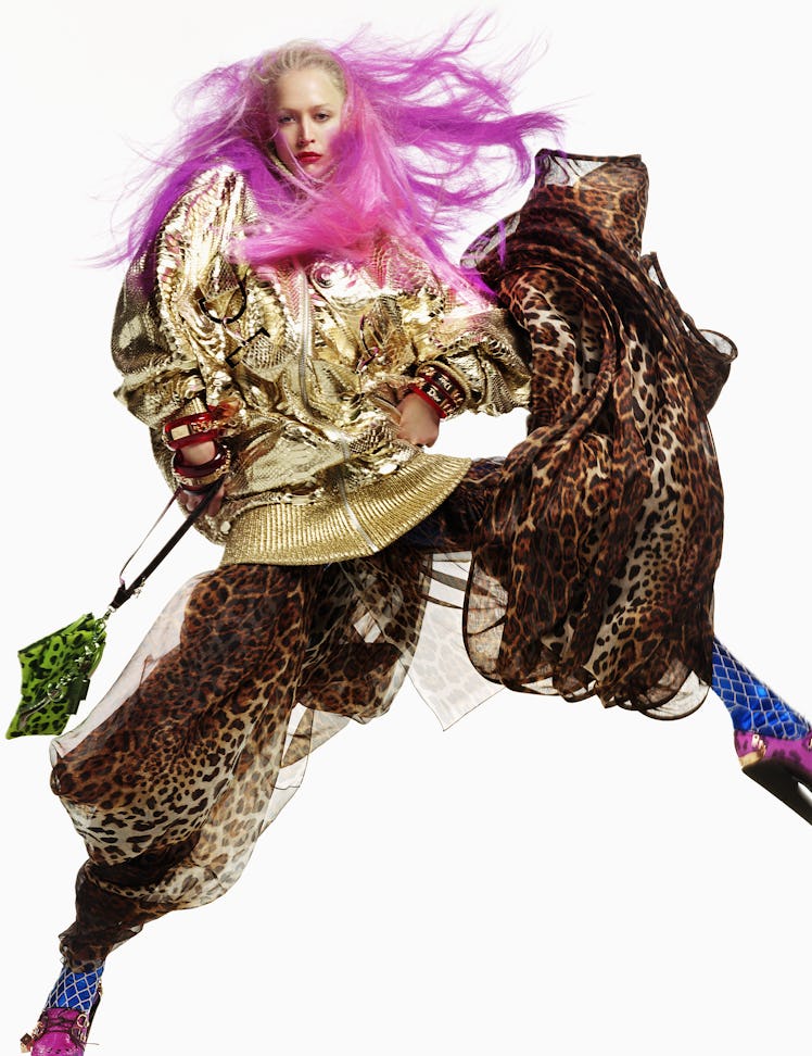Model Raquel Zimmerman posing with pink hair in a gold sequin jacket and a leopard-print skirt