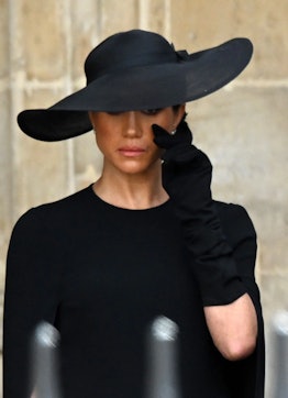 Meghan Markle, the Duchess of Sussex, wearing all black, shedding a tear at the state funeral of Que...