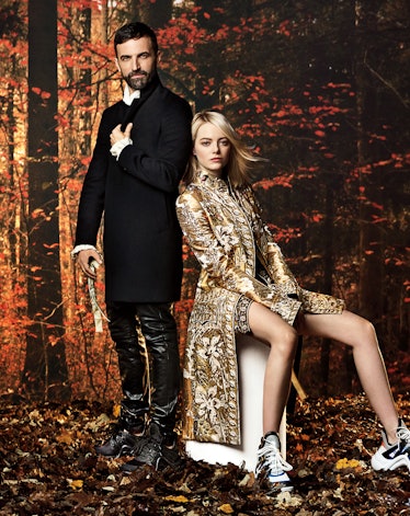 Emma Stone in a gold-white coat & Nicolas Ghesquière in a black blazer and black leather trousers po...