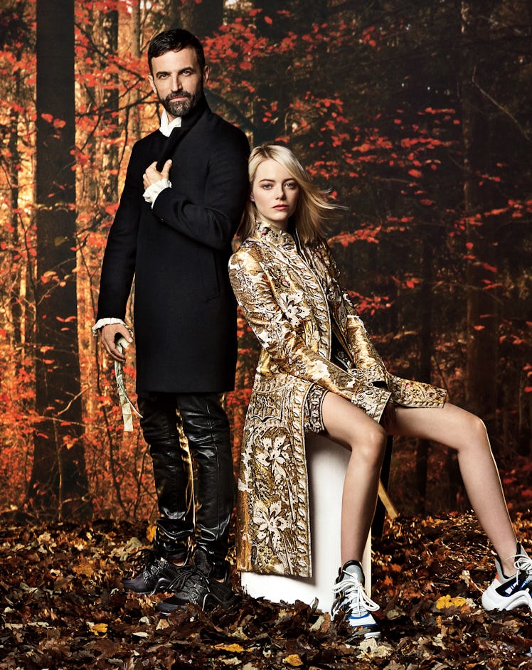 Emma Stone in a gold-white coat & Nicolas Ghesquière in a black blazer and black leather trousers po...