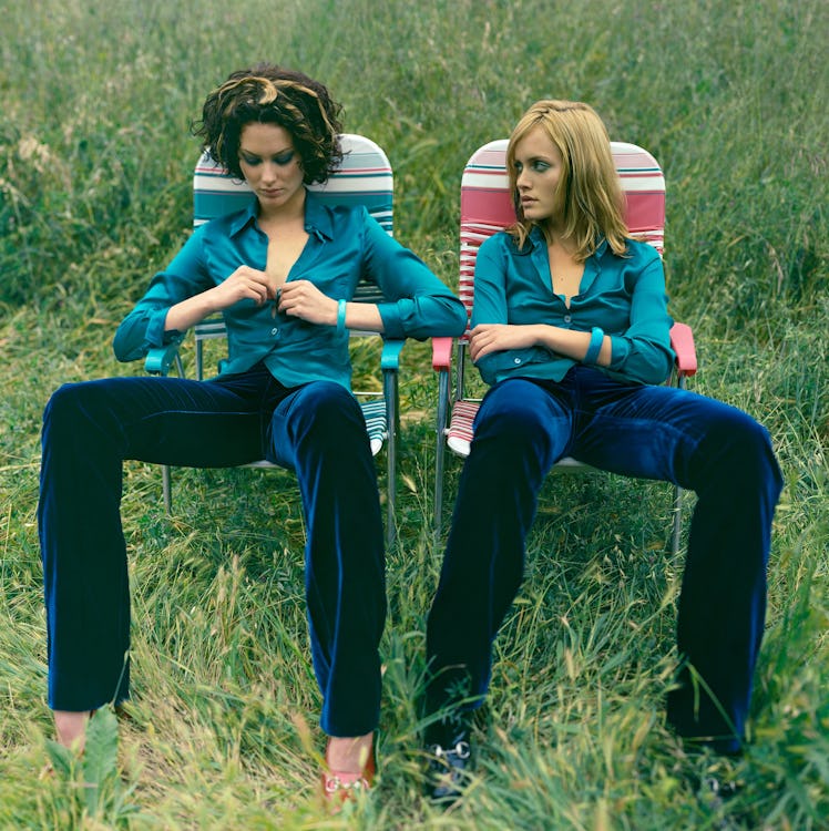 Shalom Harlow and Amber Valletta sitting in lawn chairs on a shoot for W Magazine.