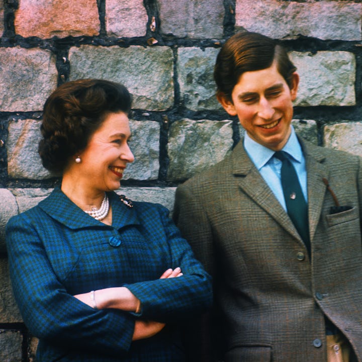 Young Queen Elizabeth and Prince Charles stand by a wall at their Windsor home.