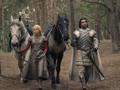 Criston Cole and Rhaenyra Targaryen walking through the woods.