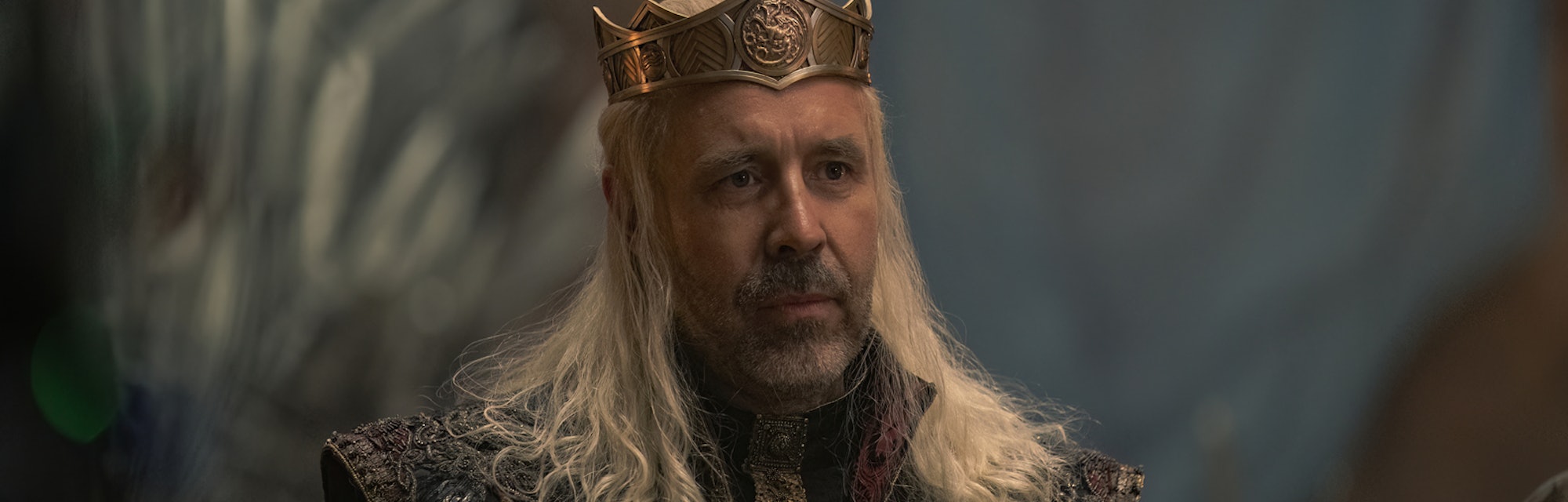 King Viserys I Targaryen (Paddy Considine) sits at a banquet table in House of the Dragon Episode 5