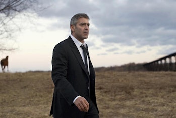 George Clooney as Michael Clayton standing in a field.