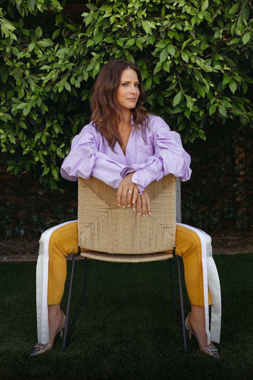 Andrea Savage Sitting Backwards On A Woven Chair