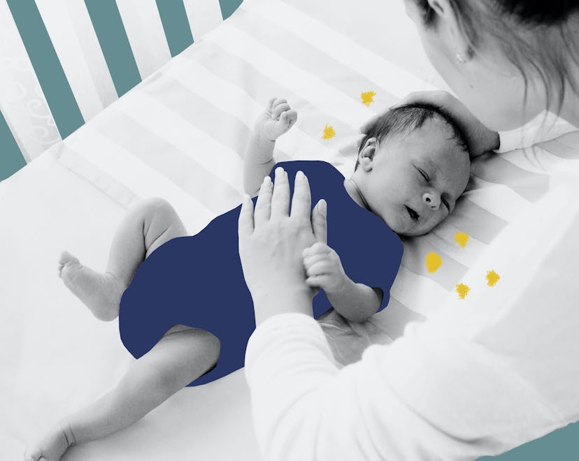 Mom with her hand on her babies chest while its lying in its crib asleep