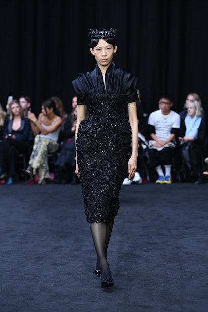 A model walking down the Richard Quinn runway at London Fashion Week with a crown on their head as a...