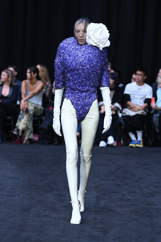 Richard Quinn’s short jumpsuit look with giant shoulder white flower and polka face mask as a tribut...