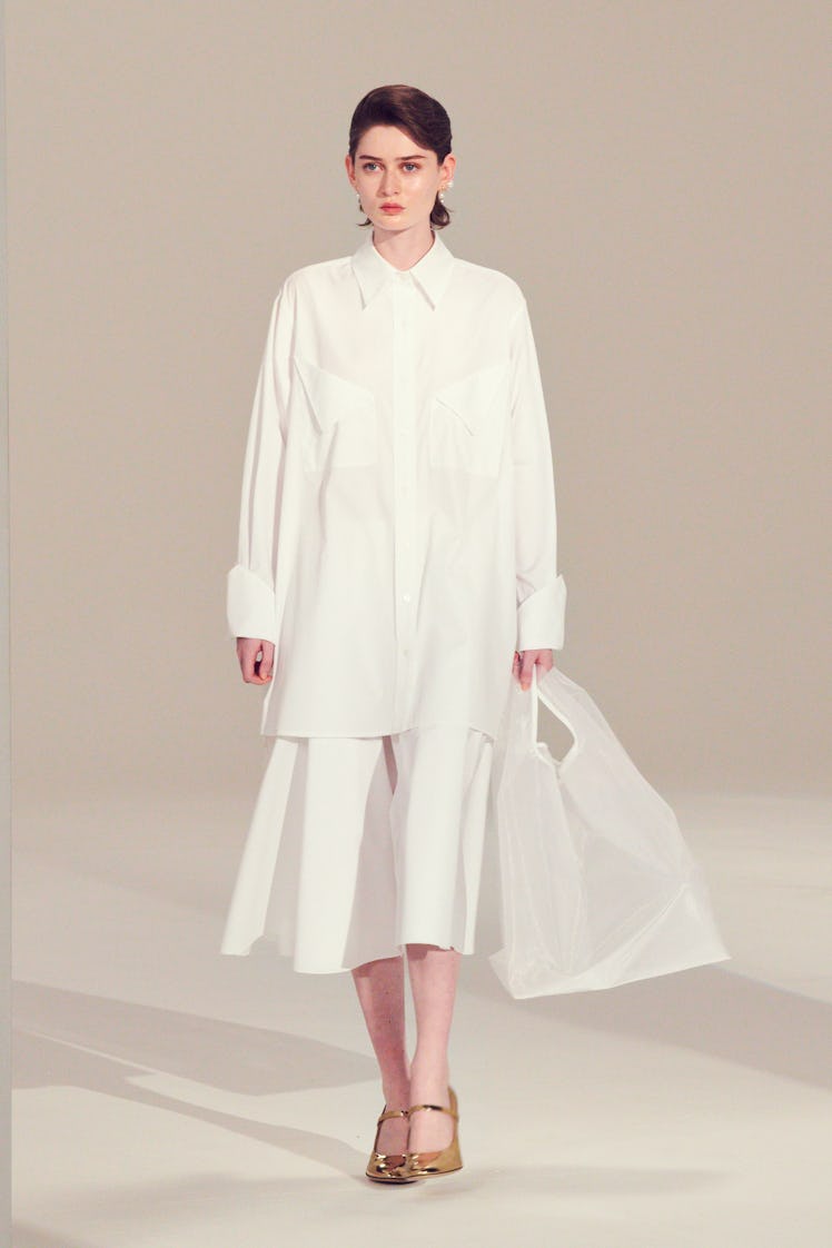 A female model walking in a white Emilia Wickstead dress  