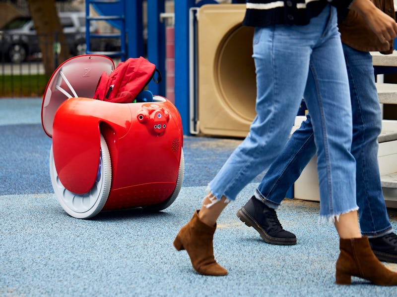 A gita robot carries people's bags on a playground.