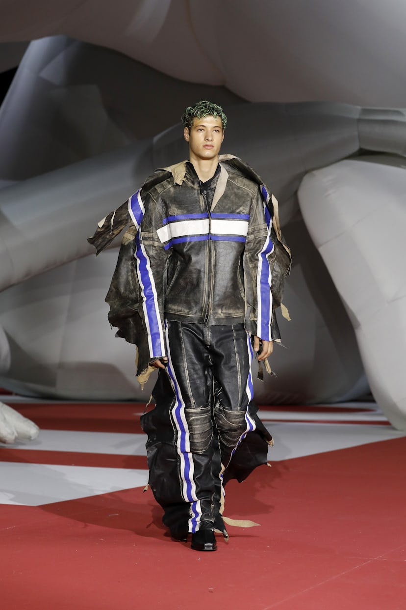 A model on the runway at Diesel Spring 2023 wearing deconstructed and oversized leather racing jacke...