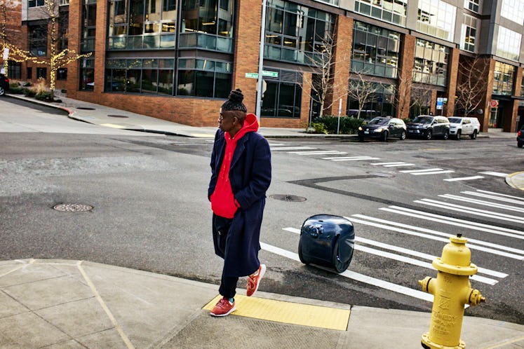 A photo of the gita robot following a user on a city street.