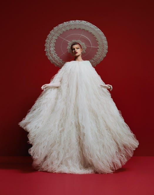 A model wearing a flying saucer hat and voluminous white gown by Harris Reed