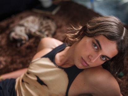 Fernando Casablancas, star of Freeform's 'The Come Up,' lying on a brown rug and posing for a photo.