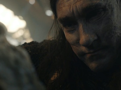 Adar (Joseph Mawle) looking down at a dying orc in The Lord of the Rings: The Rings of Power Episode...