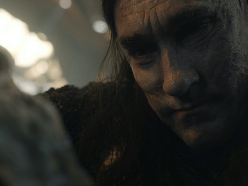 Adar (Joseph Mawle) looking down at a dying orc in The Lord of the Rings: The Rings of Power Episode...