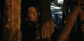 Adar (Joseph Mawle) looks through a wooden fence in The Lord of the Rings: The Rings of Power Episod...