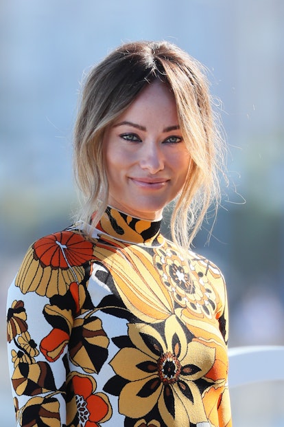 A smiling Olivia Wilde wearing a floral dress