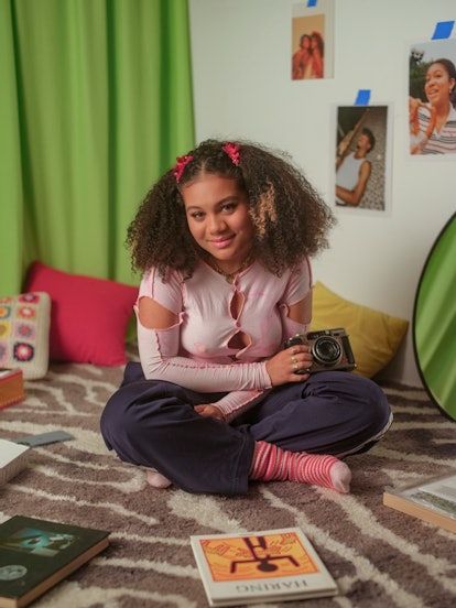 Sophia Wilson, star of Freeform's 'The Come Up,' wearing a pink top in a room with green accents, si...