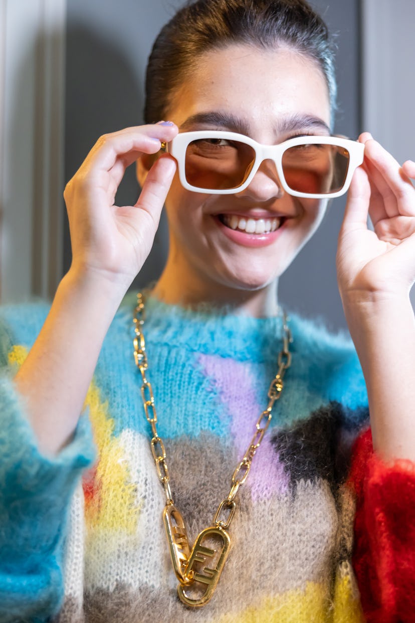 Emily Carey wearing white sunglasses and smiling