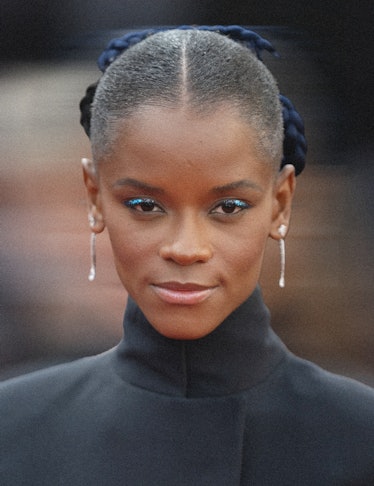 A photo of Letitia Wright with her hair parted in the middle in a slicked back style with a navy bow