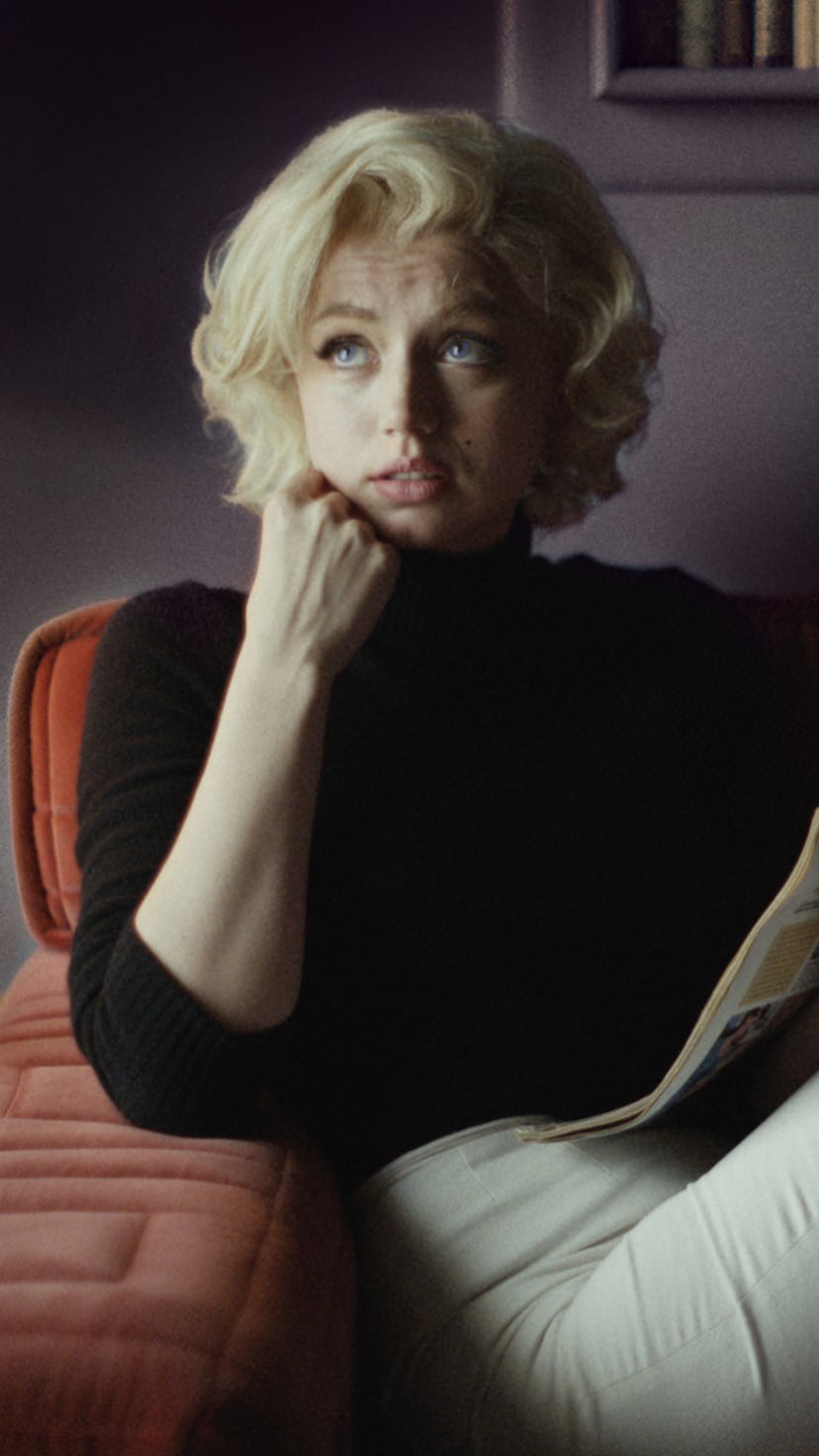 Ana De Armas sitting in a black sweater