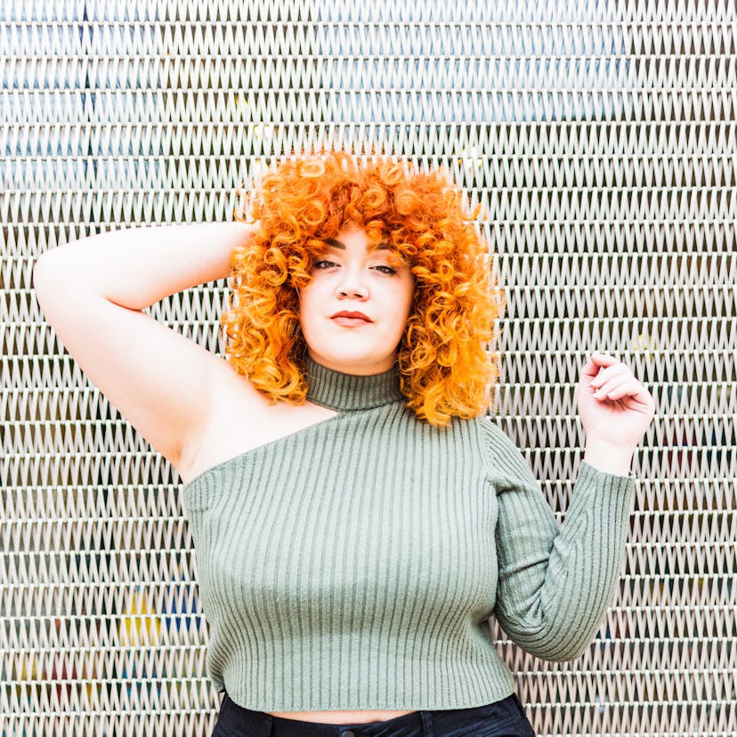 Young woman with her hand in her hair because October 2022 will be the worst month for her zodiac si...