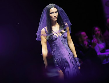 Bella Hadid walking in the Versace show at Milan Fashion Week wearing a purple gown and veil