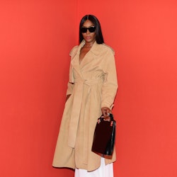 Naomi Campbell posing for a photo in a light brown coat at Milan Fashion Week