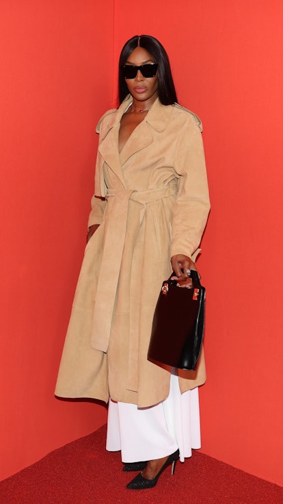 Naomi Campbell posing for a photo in a light brown coat at Milan Fashion Week