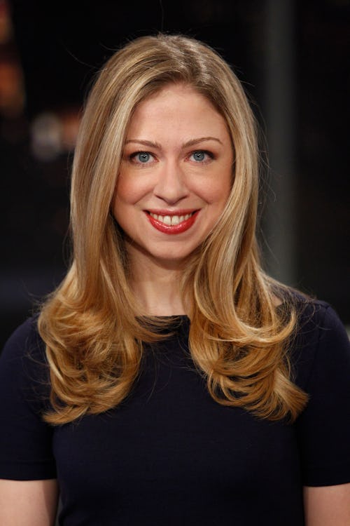 Chelsea Clinton in a navy blue t shirt smiling and posing for a photo