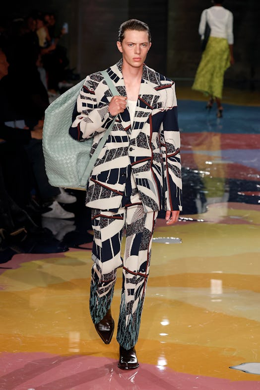 A male model walks the Bottega Veneta Spring 2023 runway in a multicolor pattern suit with oversize ...