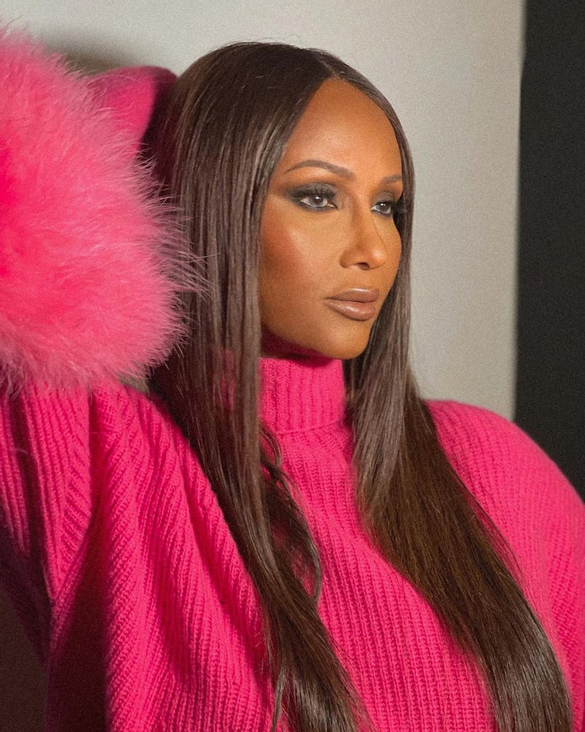 Iman wearing a bright pink sweater with a feathery ruff