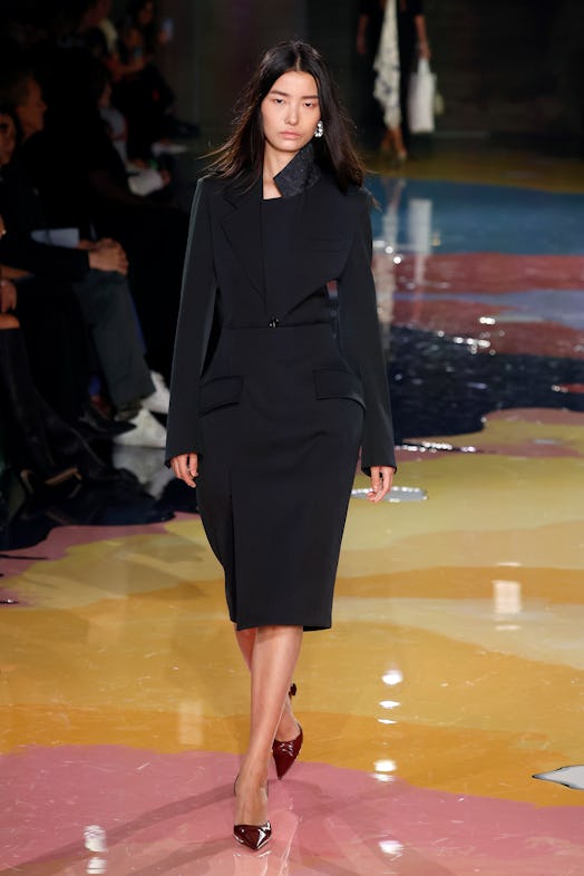 A model walks the Bottega Veneta Spring 2023 runway in a black long sleeve dress.