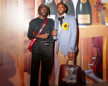 Dev Hynes and Jeremy O. Harris posing at a Krug Champagne party