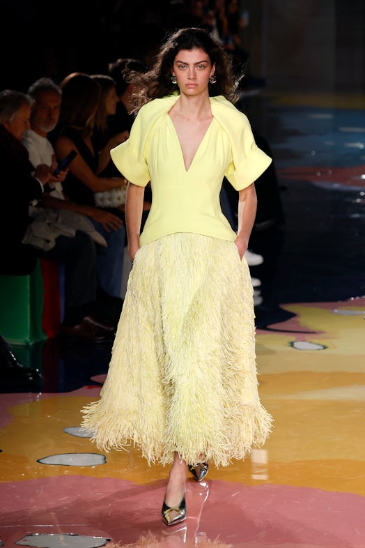 A model walks the Bottega Veneta Spring 2023 runway in light yellow furry skirt and V-neck t-shirt.