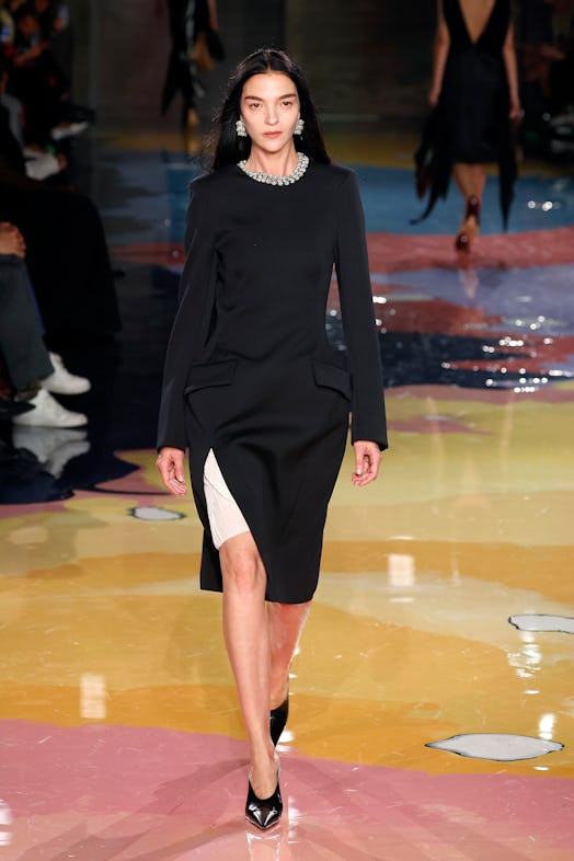 A model walks the Bottega Veneta Spring 2023 runway in a black and white dress.
