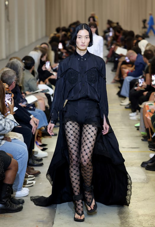 A female model walking the runway at the Burberry show during London Fashion Week in a black gown