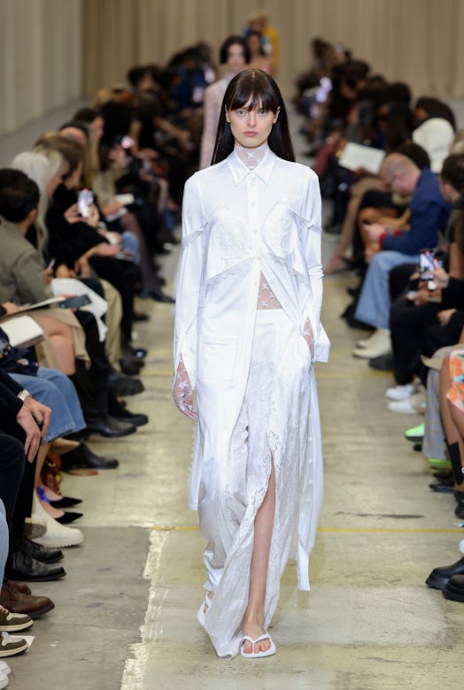 A female model in a white dress walking the runway at the Burberry show during London Fashion Week S...