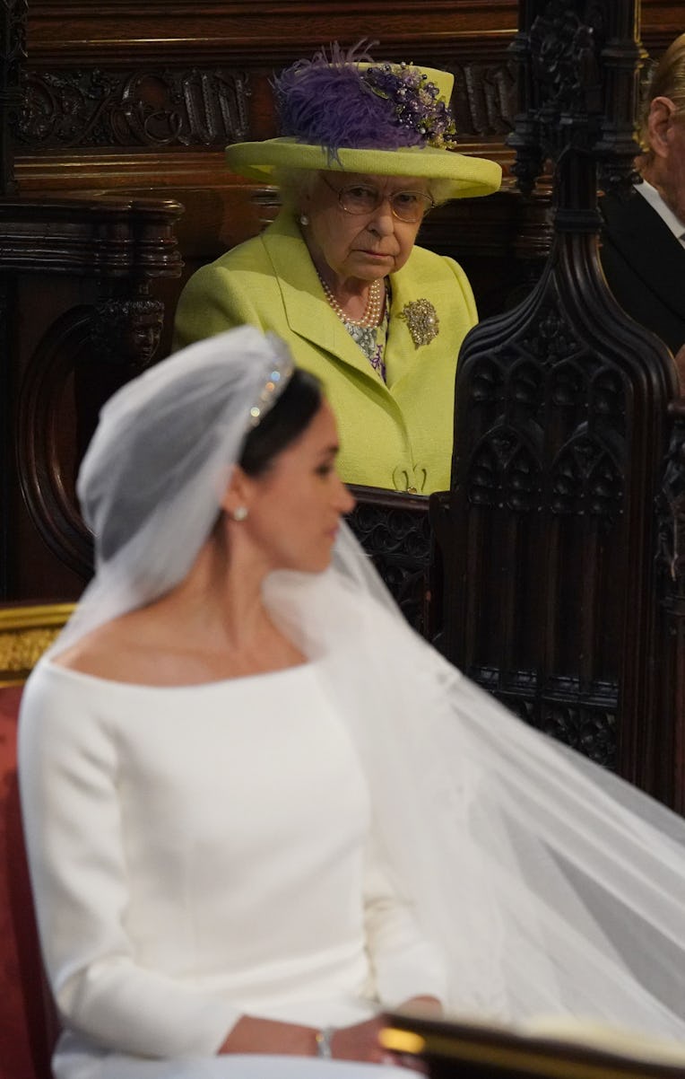 Meghan Markle in her wedding dress while the Queen is scowling at her.